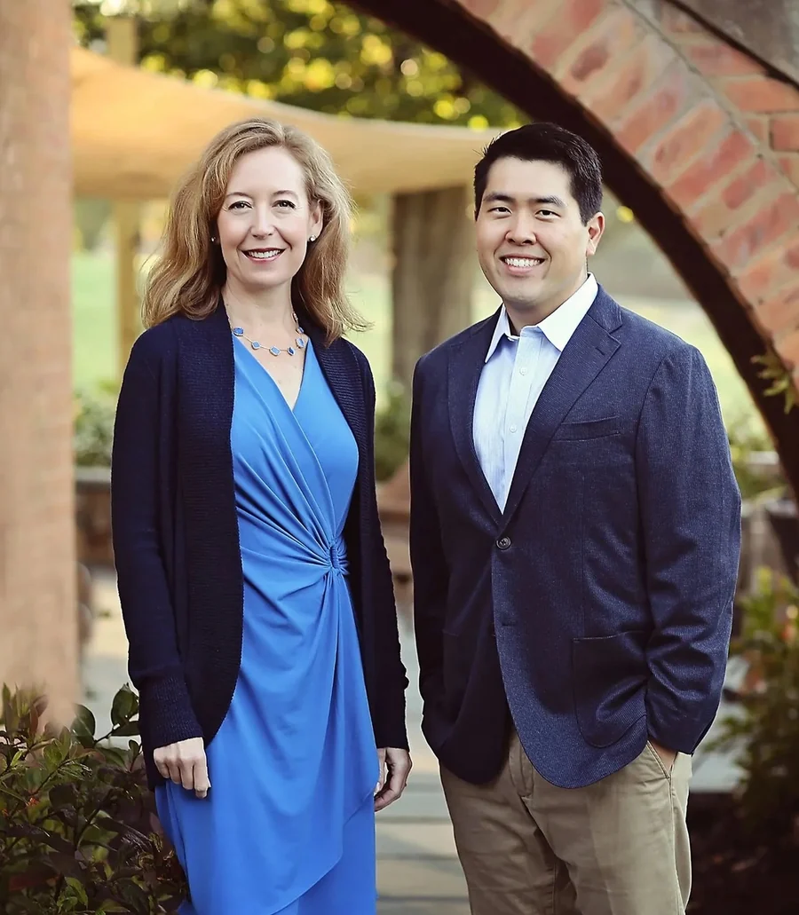Dr. Krista Davis and Dr. Jimmy Lee standing together under a brick archway.