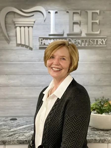 Donna, of the Lee Family Dentistry team, in front of the office sign.